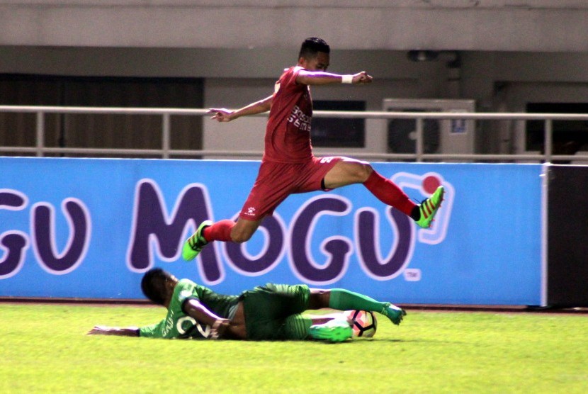 Pesepak bola PSM Makassar Reva Aditama (atas) dalam suatu laga Liga 1 Indonesia. Reva adalah salah satu pemain U-23 PSM Makassar.