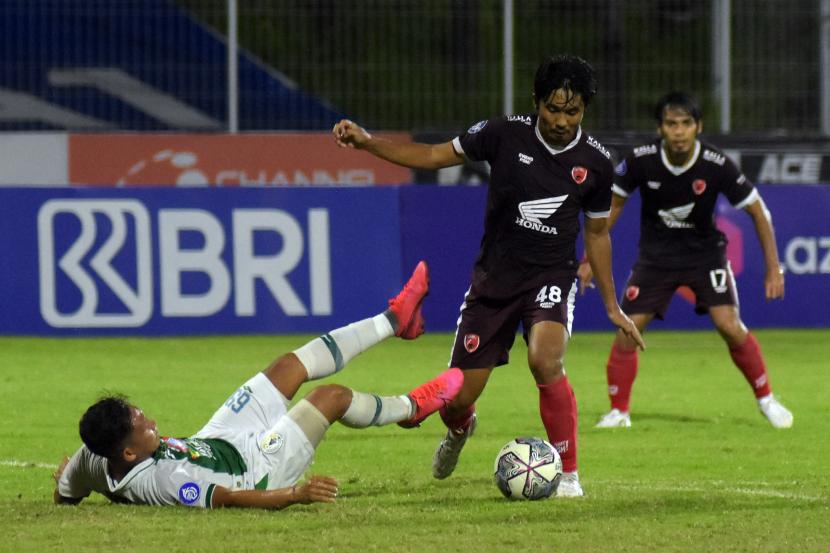 Pesepak bola PSM Makassar Arfan (tengah) berebut bola dengan pesepak bola PSS Sleman Derry Rachman (kiri) pada pertandingan Liga 1 di Stadion I Gusti Ngurah Rai, Denpasar, Bali, Selasa (1/3/2022). Pertandingan tersebut berakhir imbang dengan skor 0-0.