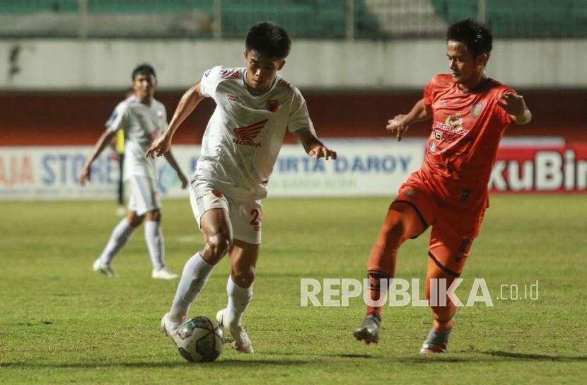 Pesepak bola PSM Makassar M. Riski (kiri) berusaha melepaskan diri dari hadangan pesepak bola Persiraja Banda Aceh Muhamad Roby (kanan) saat pertandingan Liga 1 di Stadion Maguwoharjo, Sleman, DI Yogyakarta, Senin (13/12/2021). Pertandingan tersebut berakhir imbang dengan skor 0-0. 