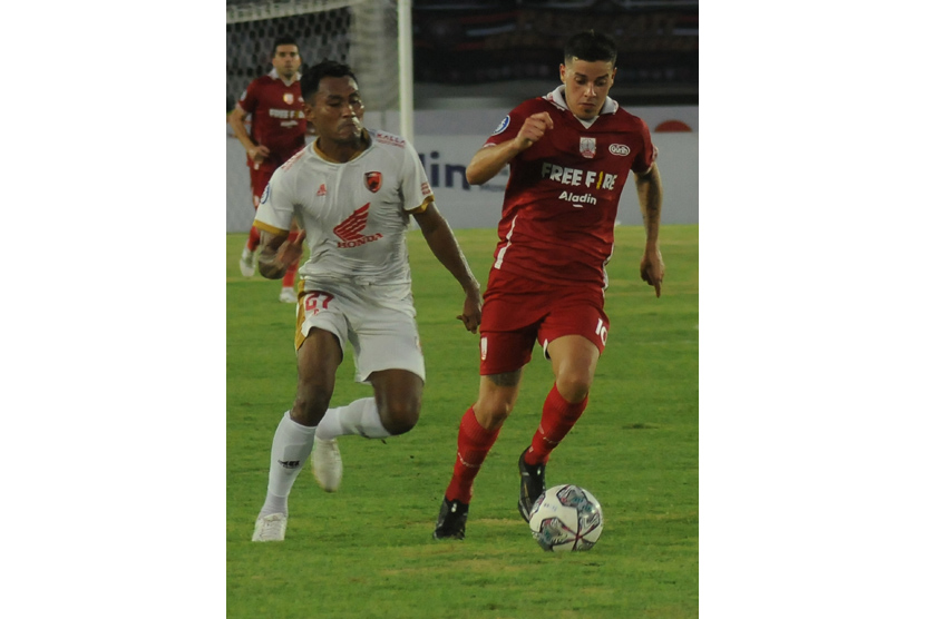 Pesepak bola PSM Makassar Safrudin Tahar (kiri) berebut bola dengan pesepak bola Persis Solo Alexis Nahuel Messidoro (kanan) pada pertandingan Liga 1 2022 di Stadion Manahan, Solo, Jawa Tengah, Kamis (29/9/2022). Dalam pertandingan Persis Solo melawan PSM Makassar tersebut berakhir imbang 1-1. 
