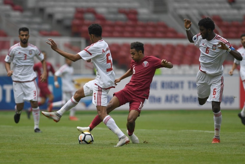 Pesepak Bola Qatar Hashim Ali (kedua kanan) berusaha melewati hadangan tiga pesepak bola Uni Emirat Arab (UEA) dalam laga Grup A Piala Asia U-19 di Stadion Utama Gelora Bung Karno, Jakarta, Kamis (18/10/2018).
