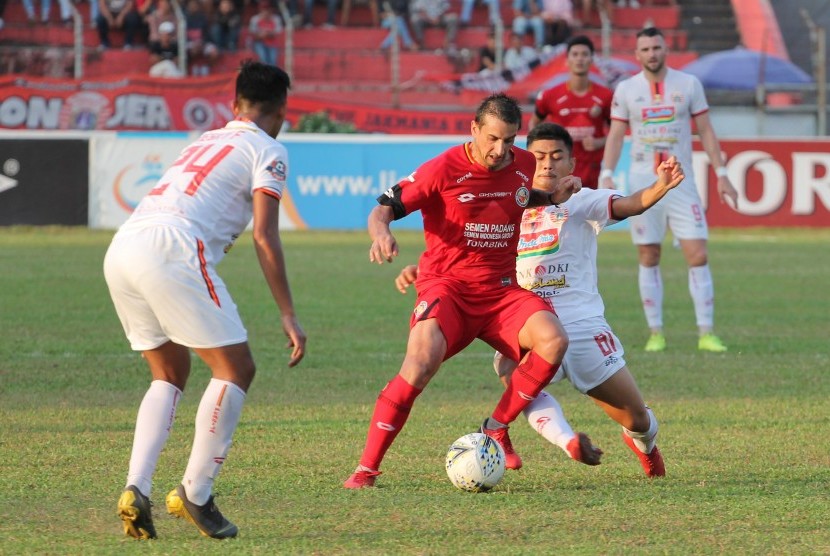 Pesepak bola Semen Padang FC Flavio Beck Junior (tengah) berebut bola dengan pesepak bola Persija Jakarta Dwi Arya (kanan) pada pertandingan lanjutan Liga 1 2019 di Stadion GOR H Agus Salim, Padang, Sumatera Barat, Kamis (7/11/2019).