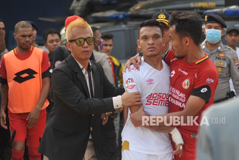 Pesepak bola Semen Padang FC, Muhammad Rifqi (kanan) berusaha menenangkan pemain PSM Makassar, Ferdinand Sinaga (tengah) akibat insiden cederanya kiper Rivky Mokodompit, pada pertandingan lanjutan putaran kedua, Liga 1, di Stadion GOR H Agus Salim Padang, Sumatera Barat, Senin (23/9/2019). 