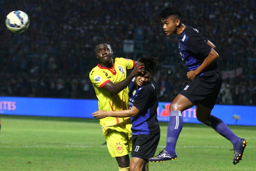 Pesepak bola Sriwijaya FC, A. Maiga (kiri), berebut bola dengan pesepakbola Arema Cronus, Juanda Irawan (kanan) dan Benny wahyudi (tengah), dalam pertandingan Piala Jenderal Sudirman Grup A di Stadion Kanjuruhan, Malang, Jawa Timur, Ahad (22/11). 