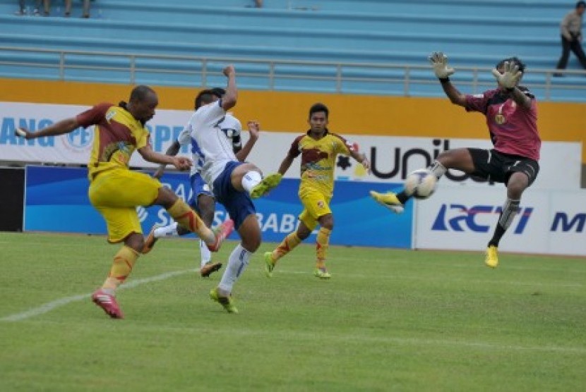 Pesepak bola Sriwijaya FC Lancine Kone (kiri) melancarkan tendangan ke arah Penjaga Gawang Barito Dedi Iman (kanan) pada Laga ISL di Stadion Gelora Sriwijaya Jakabaring, Palembang, Sumsel, Minggu ((4/5). Sriwijaya FC berhasil mengalahkan Barito Putera deng