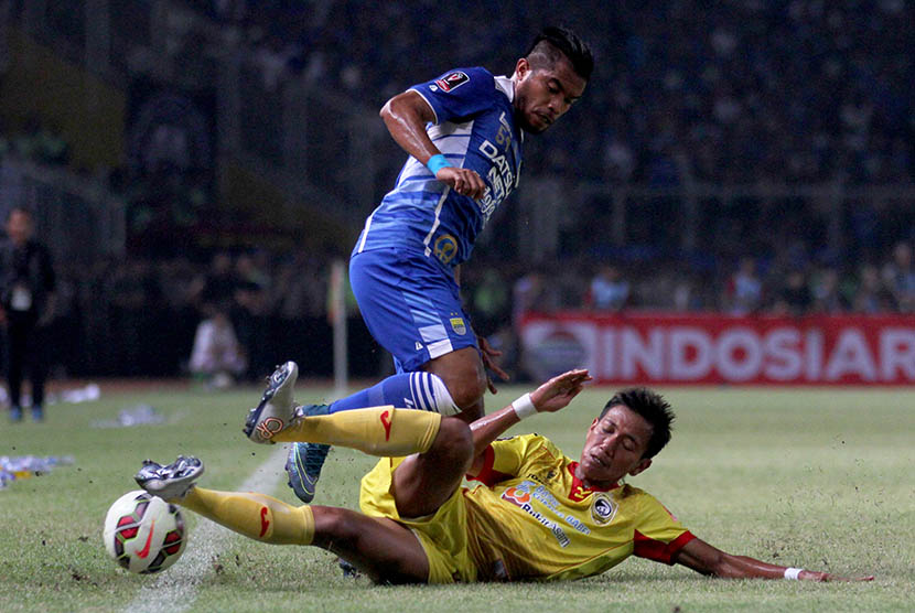 Pesepak bola Sriwijaya FC Saiful Indra (bawah) menjegal pesepak bola Persib Bandung Zulham Zamrun (atas) saat laga final Piala Presiden di Stadion Utama Gelora Bung Karno, Senayan, Jakarta, Ahad (18/10)