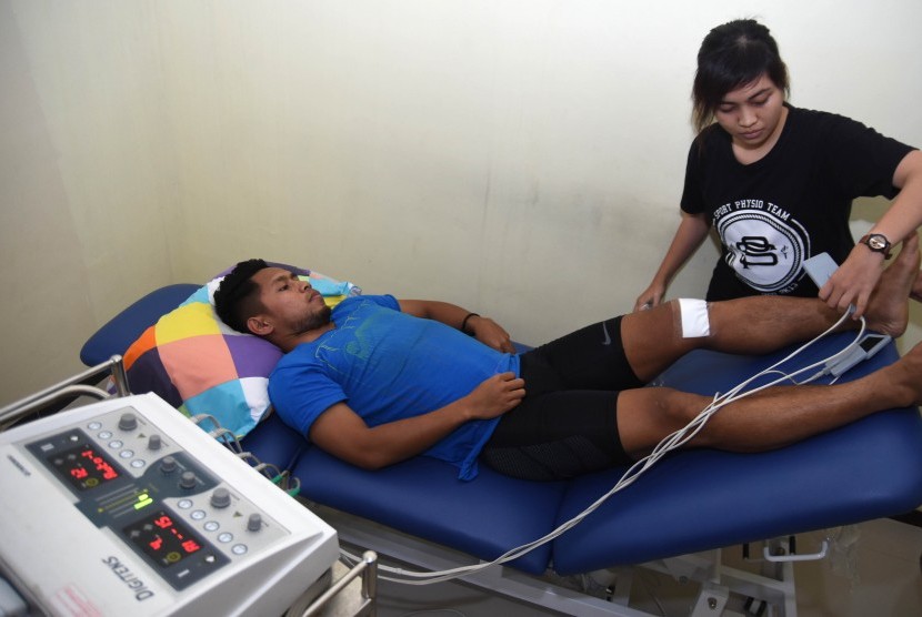 Andik Vermansah (kiri) menjalani terapi penyembuhan cedera di Physiopreneur Sport Physiotherapy kawasan Surabaya Barat, Jawa Timur beberapa waktu lalu.