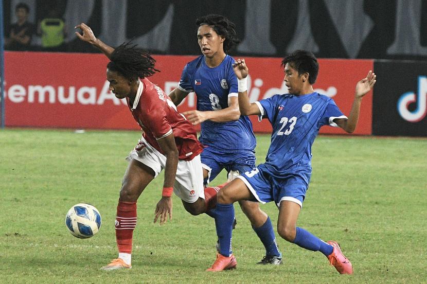 Pesepak bola Tim Nasional Indonesia U-19 Ronaldo Kwateh (kiri) menguasai bola dengan dikawal dua pesepak bola Tim Nasional Filipina U-19 dalam laga penyisihan Grup Piala AFF U-19 2022 di Stadion Patriot Chandrabhaga, Bekasi, Jawa Barat, Jumat (8/7/2022). Indonesia menang dengan skor 5-1. 
