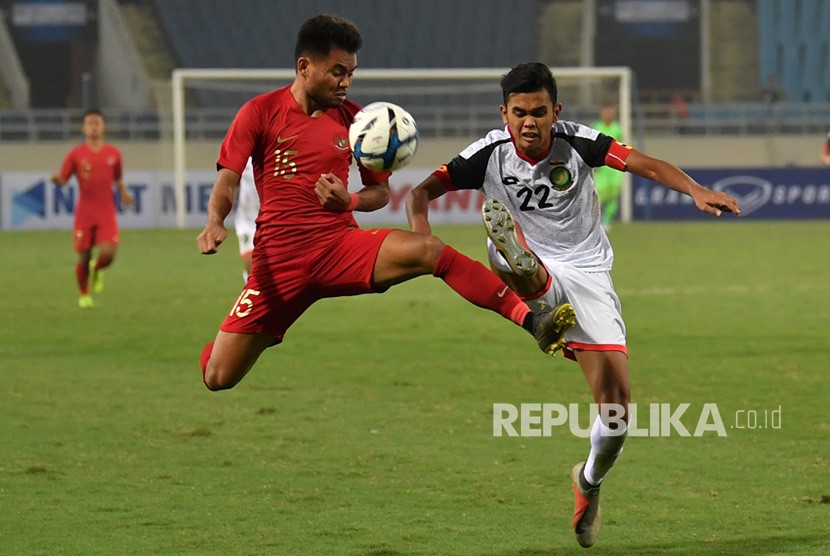 Pesepak bola tim nasional Indonesia U-23 Saddil Ramdani (kiri) berebut bola dengan pesepak bola tim nasional Brunei Darussalam U-23 Muhammad Hanif Hamir (kanan) pada pertandingan Grup K kualifikasi Piala Asia U-23 AFC 2020 di Stadion Nasional My Dinh, Hanoi, Vietnam, Selasa (25/3/2019). 