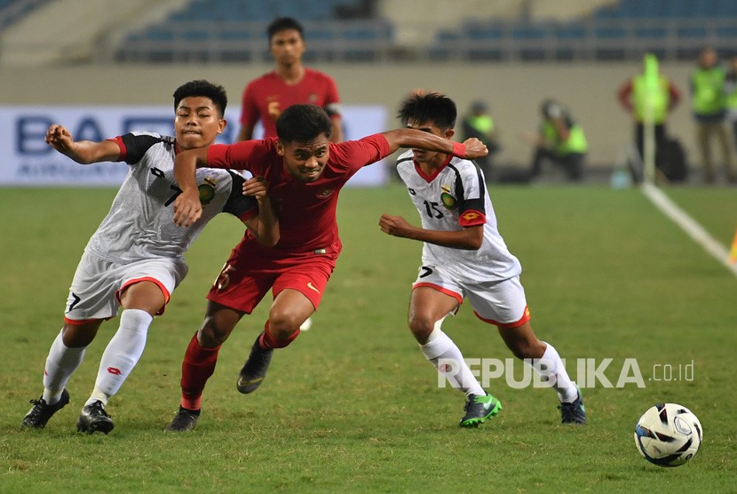 Pesepak bola tim nasional Indonesia U-23 Saddil Ramdani (tengah) berupaya meloloskan diri dari kawalan dua pesepak bola tim nasional Brunei Darussalam U-23 Muhammad Nur (kiri) dan Rahmin Abdul Ghani (kanan), pada pertandingan Grup K kualifikasi Piala Asia U-23 AFC 2020 di Stadion Nasional My Dinh, Hanoi, Vietnam, Selasa (26/3/2019). 