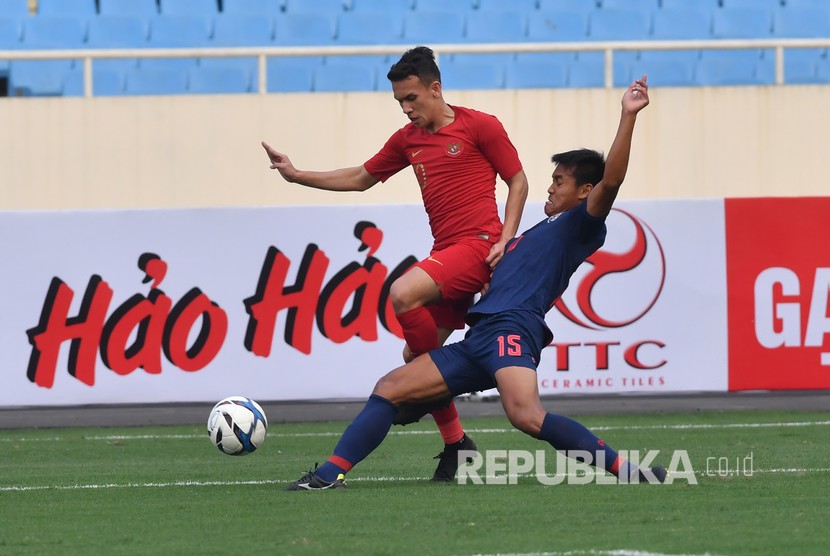 Pesepak bola tim nasional U-23 Indonesia Egy Maulana Vikri (kiri) berupaya melewati pesepak bola tim nasional U-23 Thailand Saringkan Promsupa (kanan) pada pertandingan perdana Grup K kualifikasi Piala Asia U-23 AFC 2020, di Stadion Nasional My Dinh, Hanoi, Vietnam, Jumat (22/3/2019).