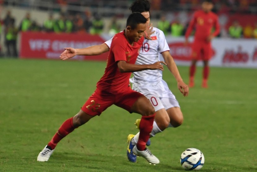 Gelandang timnas Indonesia U-23 Sani Rizki (kiri) berupaya melewati pemain Vietnam U-23 Truong Van Thay Qui pada pertandingan sepak bola Grup K kualifikasi Piala AFC U-23 di Stadion Nasional My Dinh, Hanoi, Vietnam, Ahad (24/3/2019). 