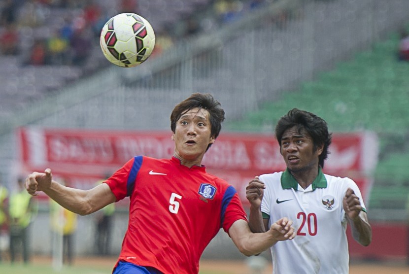 Pesepak bola Timnas Indonesia Ilham Udin Armaiyn (kanan) berebut bola dengan pesepak bola Timnas Korsel Woo Jusung pada pertandingan kualifikasi Grup H Kejuaraan Piala Asia (AFC) U-23 Tahun 2016 di Stadion Utama Gelora Bung Karno, Senayan, Jakarta, Selasa 