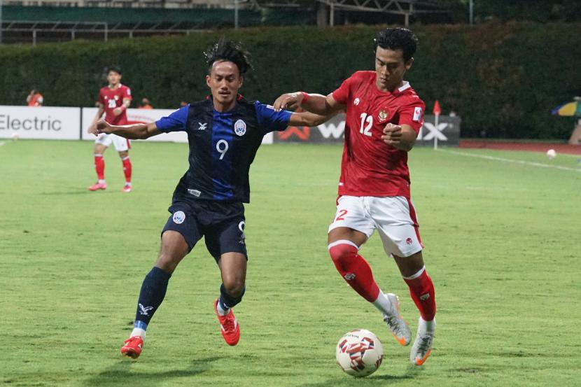 Pesepak bola Timnas Indonesia Pratama Arhan berebut bola dengan pesepak bola Kamboja Sieng Chantea (kiri) dalam pertandingan grup B Piala AFF 2020 di Stadion Bishan, Singapura, Kamis (9/12/21). Indonesia menang dengan skor 4-2. 