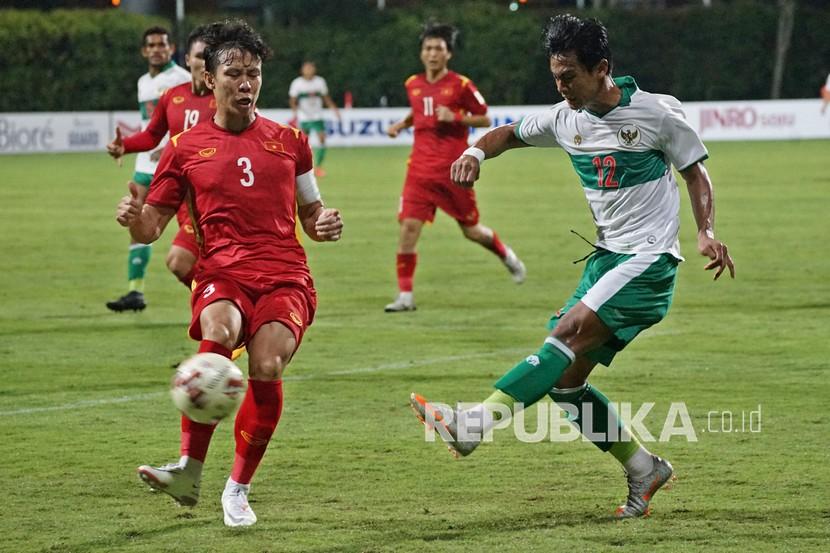 Bek kiri Timnas Indonesia Pratama Arhan (kanan) berebut bola dengan pesepak bola Timnas Vietnam Que Ngoc Hai (kiri) dalam pertandingan grup B Piala AFF 2020 di Stadion Bishan, Singapura, Rabu (15/12). Pada hari ini Indonesia akan melakoni laga terakhir Grup B melawan Malaysia.