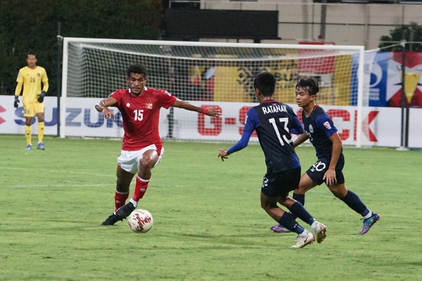 Pesepak bola Timnas Indonesia Ramai Rumakiek (kiri) berusaha melewati hadangan dua pesepak bola Timnas Kamboja dalam pertandingan grup B Piala AFF 2020 di Stadion Bishan, Singapura, Kamis (9/12/21). Indonesia menang dengan skor 4-2.