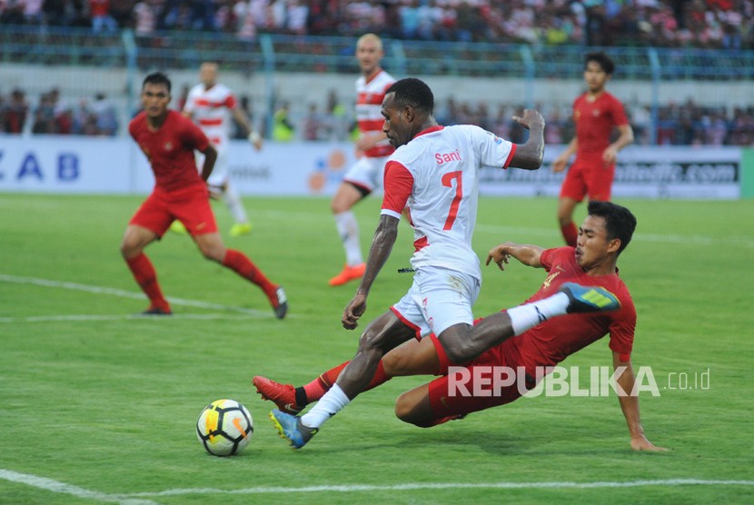 Pesepak bola Timnas U-22 Asnawi Mangku Alam (kanan) berusaha menghentikan pesepak bola Madura United FC (MU) Engelberd Sani (tengah) saat laga uji coba di Stadion Gelora Bangkalan (SGB) Bangkalan, Jawa Timur, Selasa (12/2/2019).