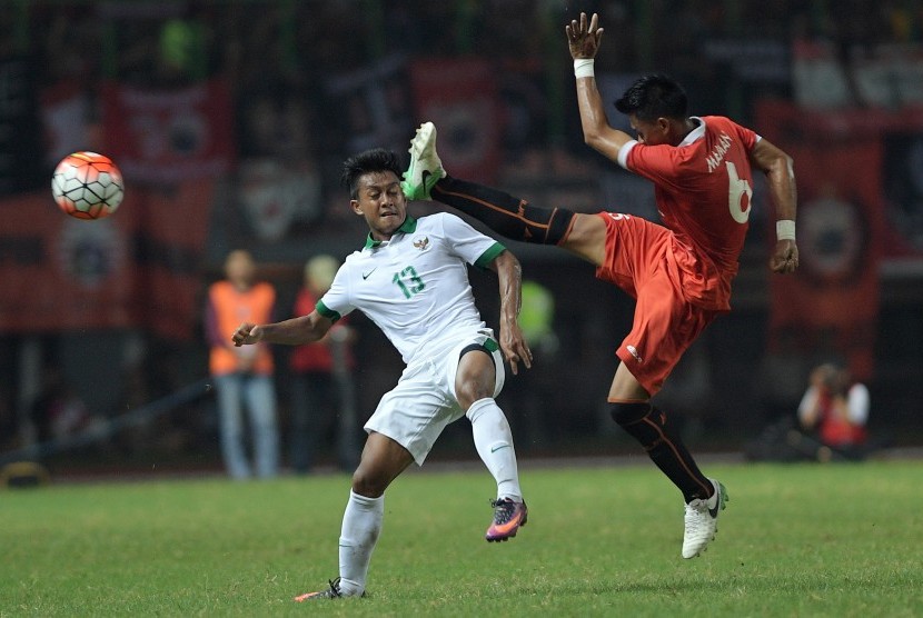 Pesepak bola Timnas U-22 Febri Haryadi (kiri) berebut bola dengan pesepak bola Persija Jakarta Maman Abdurrahman (kanan) dalam pertandingan uji coba di Stadion Patriot Chandrabhaga, Bekasi, Jawa Barat, Rabu (5/4).