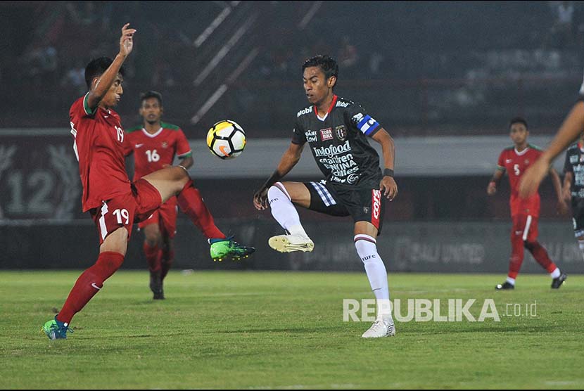 Pesepak bola Timnas U-23 Hanif (kiri) berebut bola dengan pesepak bola Bali United Fadil Sausu (ketiga kiri) dalam laga uji coba jelang Asian Games 2018 di Stadion I Wayan Dipta, Gianyar, Bali, Selasa (31/7).