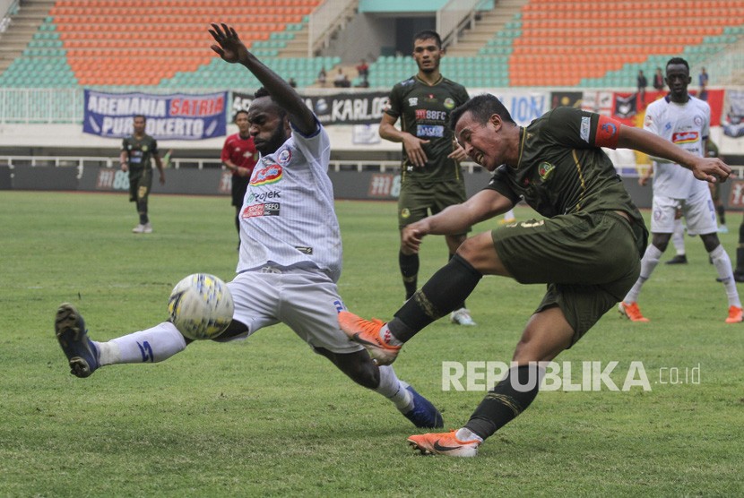 Pesepak bola Tira Persikabo Guntur Triaji (kanan) menendang bola yang dihadang pesepak bola Arema FC Riky Kayame (kiri) pada lanjutan Liga 1 2019 di Stadion Pakansari, Cibinong, Bogor, Jawa Barat, Kamis (24/10/2019).