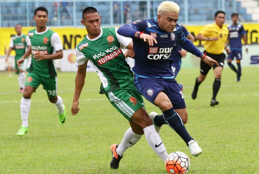 Pesepakbola Arema FC, Cristian Gonzales (kanan) berusaha melewati hadangan pesepakbola PS TNI, Andi Setyo Nugroho (kiri) dalam pertandingan Piala Presiden Grup 2 di Stadion Kanjuruhan, Malang, Jawa Timur, Kamis (16/2).