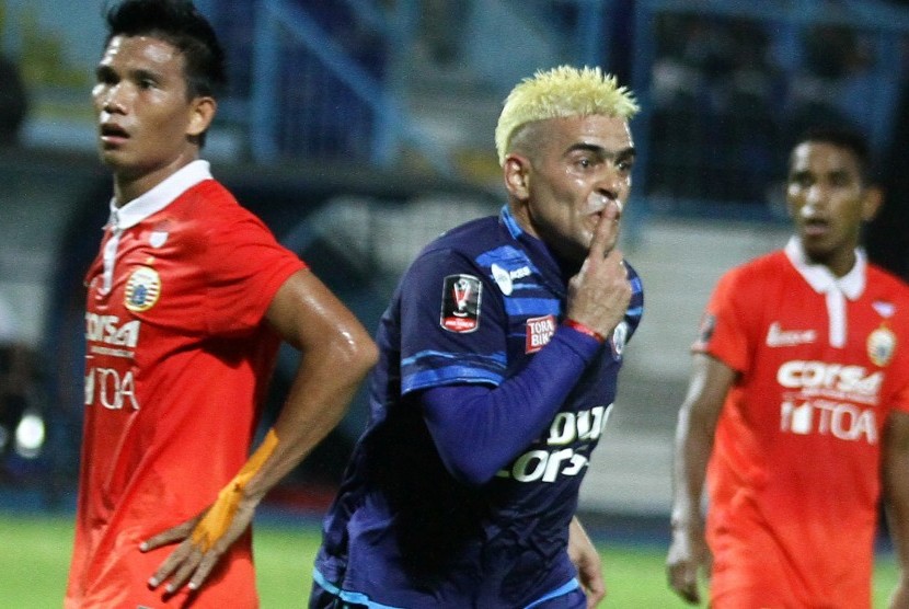 Pesepakbola Arema FC, Cristian Gonzales (tengah) melakukan selebrasi usai mencetak gol di gawang Persija Jakarta yang dikawal pesepakbola Sandi Darma Sutte (kiri) dalam pertandingan Piala Presiden di Stadion Kanjuruhan, Malang, Jawa Timur, Sabtu (11/2). 