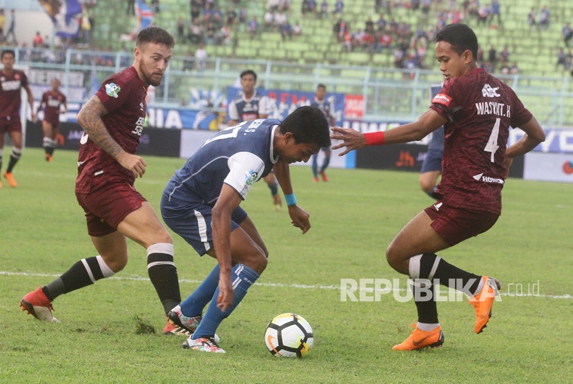 Pesepakbola Arema FC, Dedik Setiawan (tengah) berusaha melepaskan diri dari hadangan pesepakbola PSM Makassar, Wasyiat Hasbullah (kanan) dan Marc Anthony Klok (kiri), dalam pertandingan GOJEK LIGA I di Stadion Kanjuruhan, Malang, Jawa Timur, Ahad (13/5).