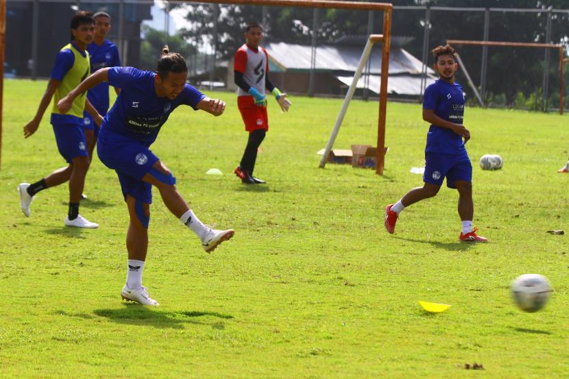Pesepakbola Arema FC, Dendy Santosa (kiri) menendang bola saat mengikuti latihan perdana di Lapangan Universitas Brawijaya, Malang, Jawa Timur, Selasa (10/5/2022). Latihan perdana tersebut dilakukan sebagai persiapan Tim Arema FC dalam menyambut musim kompetisi Liga 1 2022/2023 yang akan dimulai pada bulan Juli 2022. 