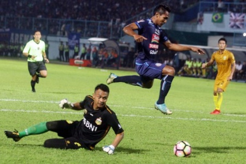 Pesepakbola Arema FC Hendro Siswanto (kanan) melompat untuk menghindari tubuh penjaga gawang Bhayangkara FC, Panggih Prio Sembodo (kiri) dalam pertandingan Piala Presiden Grup E di Stadion Kanjuruhan, Malang, Jawa Timur, Selasa (30/1). 