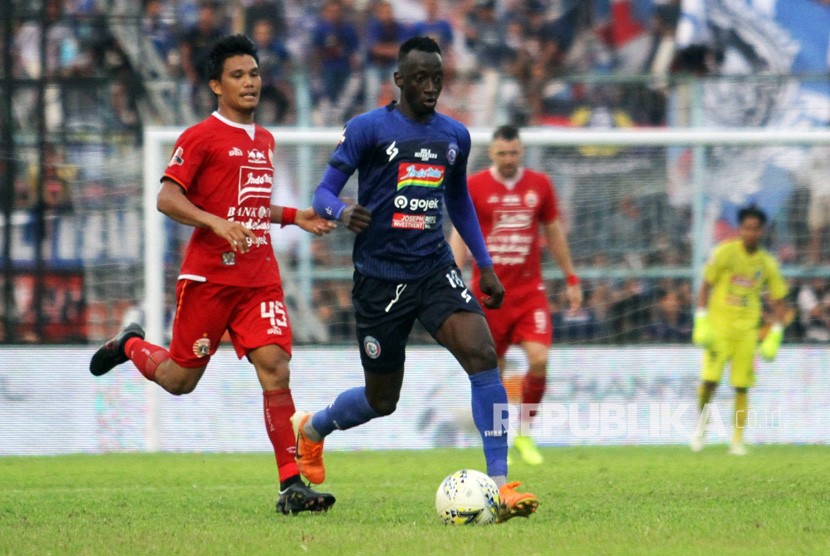 Gelandang Arema FC Makan Konate (kanan) berusaha melepaskan diri dari adangan gelandang Persija Jakarta Sandi Darman Sute (kiri) dalam lanjutan Liga 1 di Stadion Kanjuruhan, Malang, Sabtu (23/11). 