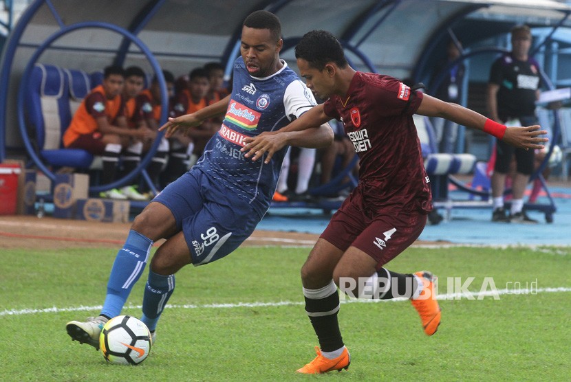 Pesepakbola Arema FC, Thiago Furtuoso (kiri) berusaha mempertahankan bola dari hadangan pesepakbola PSM Makassar, Wasyiat Hasbullah (kanan) dalam pertandingan GOJEK LIGA I di Stadion Kanjuruhan, Malang, Jawa Timur, Ahad (13/5).