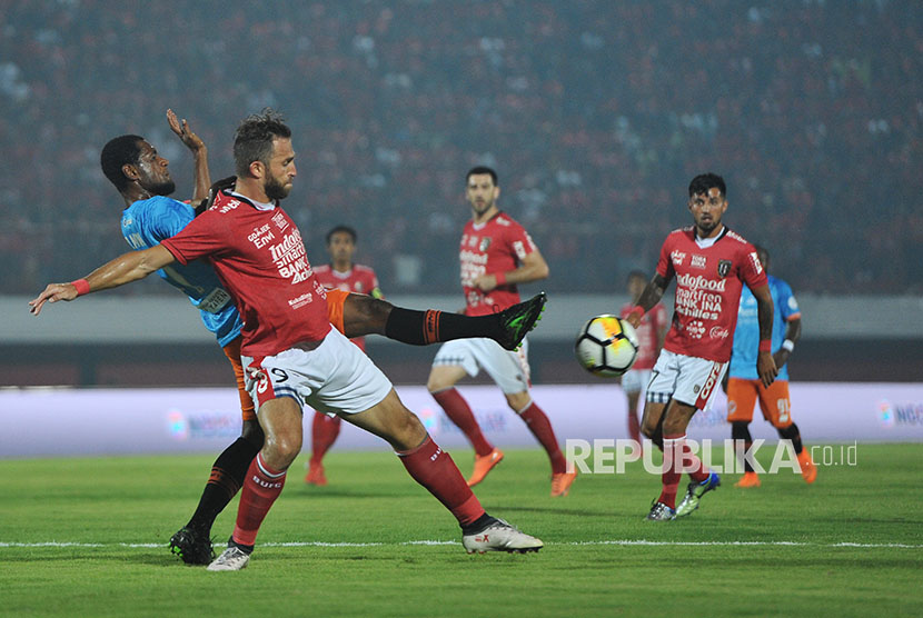 Pesepakbola Bali United Ilija Spasojevic (kedua kiri) berebut bola dengan pesepak bola Perseru Serui Donny Harold Monim (kiri) dalam pertandingan Sepak Bola Liga 1 2018 di Stadion I Wayan Dipta, Sabtu (7/4). 