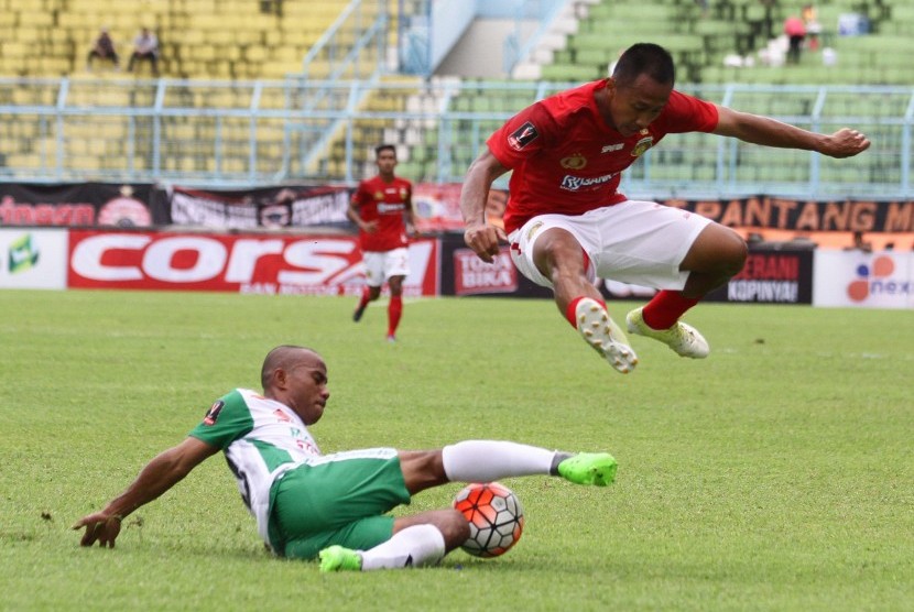 Pesepakbola Bhayangkara FC, Antoni Putro Nugroho (kanan) melompat untuk menghindari hadangan pesepakbola PS TNI, Rinto Ali (kiri) dalam pertandingan Piala Presiden di Stadion Kanjuruhan, Malang, Jawa Timur, Sabtu (11/2).