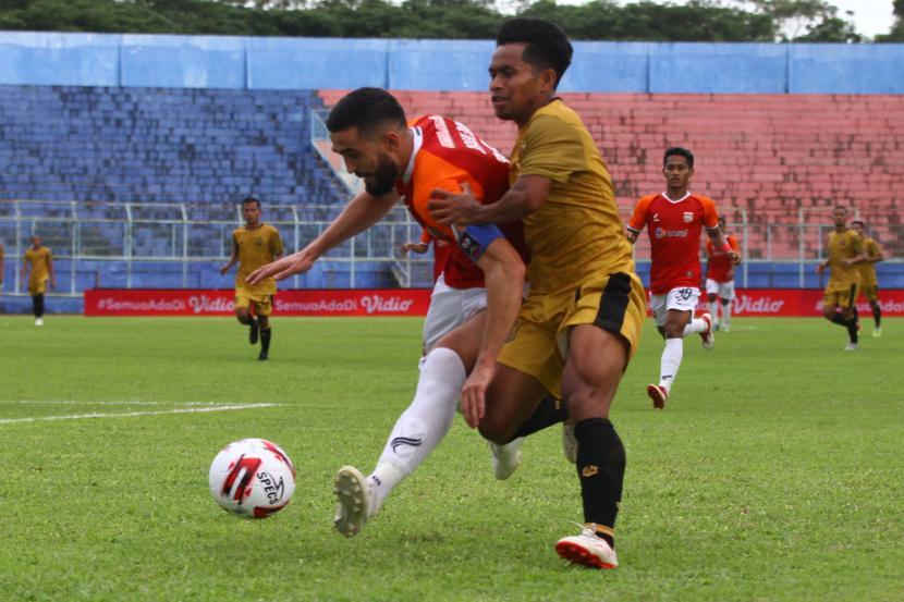 Pesepakbola Borneo FC Samarinda, Javlon Guseynov (kiri) berusaha mempertahankan bola dari pesepakbola Bhayangkara Solo FC, Andik Vermansah (kanan) dalam pertandingan babak penyisihan Grup B Piala Menpora di Stadion Kanjuruhan, Malang, Jawa Timur, Senin (22/3/2021). Bhayangkara Solo FC mengalahkan Borneo FC Samarinda dengan skor akhir 1-0. 