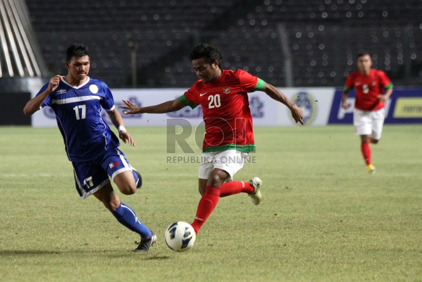 Pesepakbola Indonesia Ilham Udin berebut bola dengan pesepakbola Filipina Junel Mark saat laga grup G kualifikasi Piala AFC 2013 di Stadion Gelora Bung Karno, Kamis (10/10).  (Republika/Yasin Habibi)