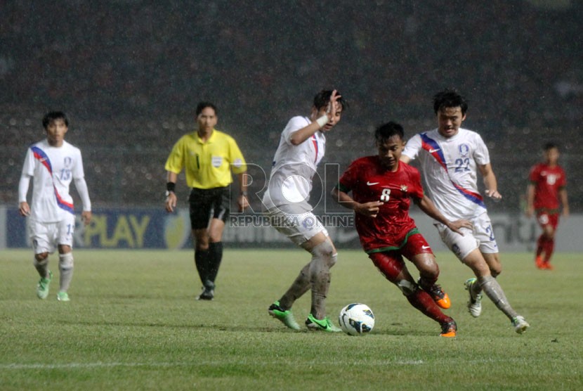    Pesepakbola Indonesia Muhammad Hargianto (merah) berebur bola dengan pemain Korea Selatan dalam laga kualifikasi group G AFC U-19 di Gelora Bung Karno, Senayan, Jakarta, Sabtu (12/10).  (Republika/Yasin Habibi)