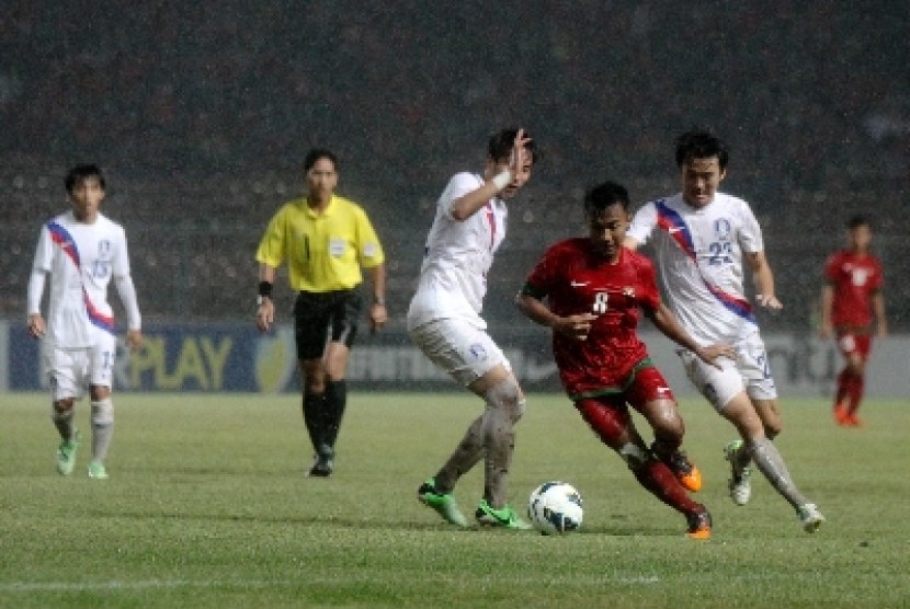 Pesepakbola Indonesia Muhammad Hargianto (merah) berebur bola dengan pemain Korea Selatan dalam laga kualifikasi group G AFC U-19 di Gelora Bung Karno, Senayan, Jakarta, Sabtu (12/10).