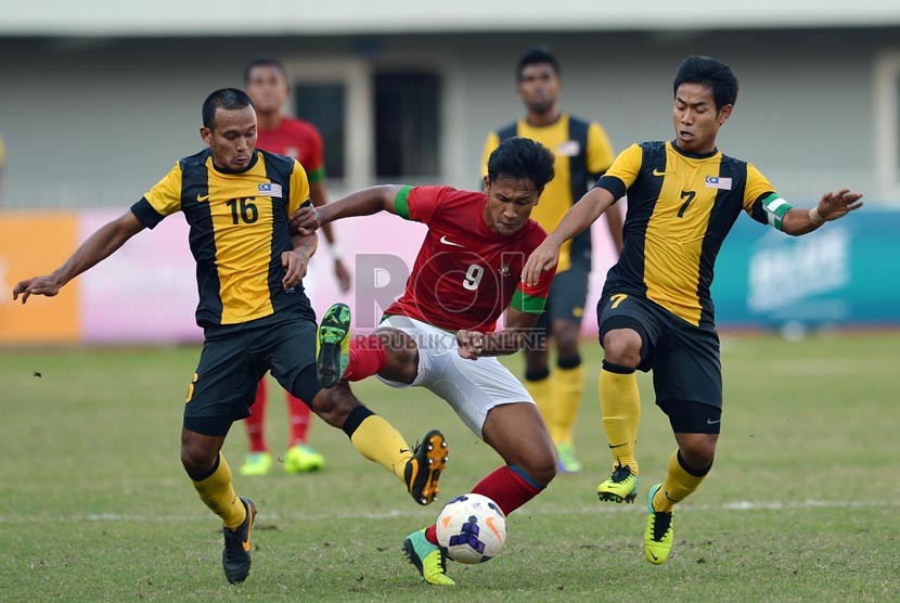    Pesepakbola Indonesia Yandi Sofyan berusaha melewati hadangan pemain Malaysia pada babak semifinal sepakbola Sea Games ke-27 di Naypyidaw, Myanmar, Kamis (19/2).