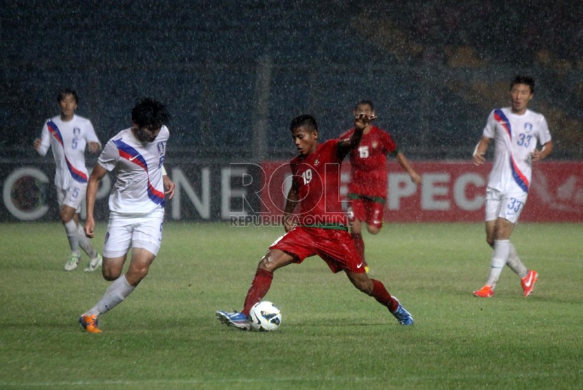   Pesepakbola Indonesia Zulfiandi (merah) berebur bola dengan pemain Korea Selatan dalam laga kualifikasi group G AFC U-19 di Gelora Bung Karno, Senayan, Jakarta, Sabtu (12/10).  (Republika/Yasin Habibi)