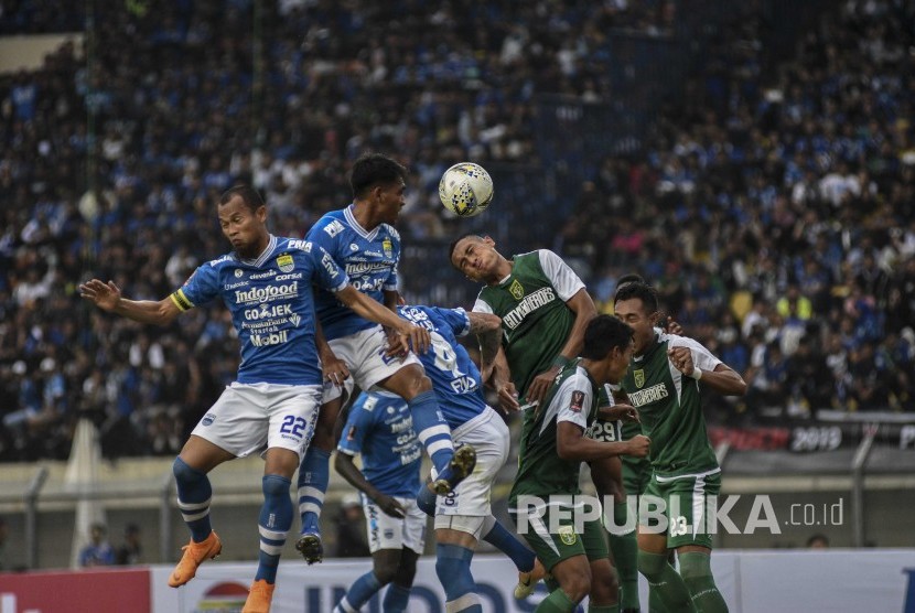 Pesepakbola Persib Bandung berebut bola dengan pesepakbola Persebaya Surabaya saat laga lanjutan Grup A Piala Presiden 2019 di Stadion Si Jalak Harupat, Kabupaten Bandung, Kamis (7/3).