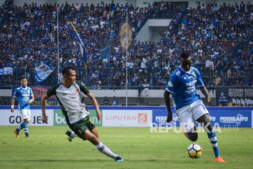 Pesepakbola Persib Bandung Ezechiel (kanan) berusaha melewati pesepakbola PS Tira Irfandi (kedua kiri) saat laga perdana Gojek Liga 1 di Stadion Gelora Bandung Lautan Api (GBLA), Bandung, Jawa Barat, Senin (26/3). 