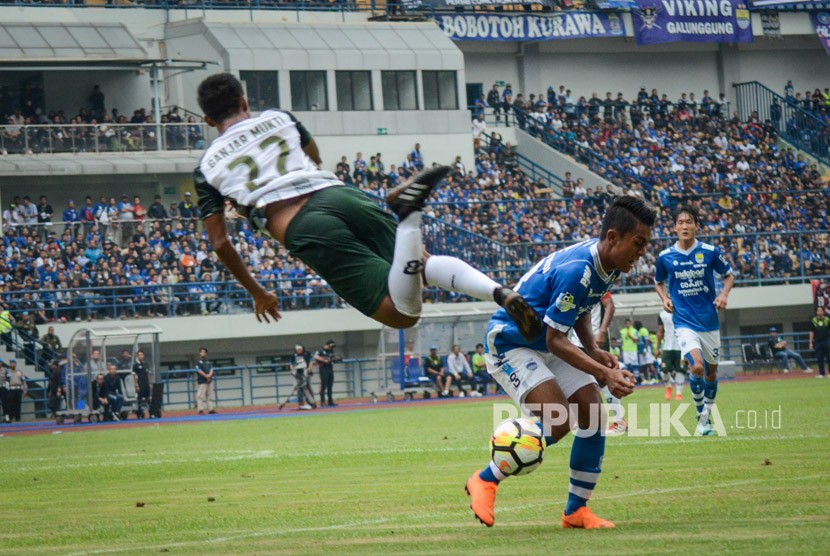 Pesepakbola Persib Bandung Febri Hariyadi (kedua kanan) berbenturan dengan pesepakbola PS Tira Ganjar Mukti (kiri) saat laga perdana Gojek Liga 1 di Stadion Gelora Bandung Lautan Api (GBLA), Bandung, Jawa Barat, Senin (26/3).