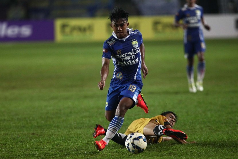 Pesepakbola Persib Bandung, Febri Hariyadi (kiri) berhasil melewati hadangan pesepakbola Mitra Kukar Maulana Bahtiar (bawah) pada laga perdana Liga Bhayangkara di Stasion Si Jalak Harupat,Kabupaten Bandung, Jawa Barat, Kamis (17/3).