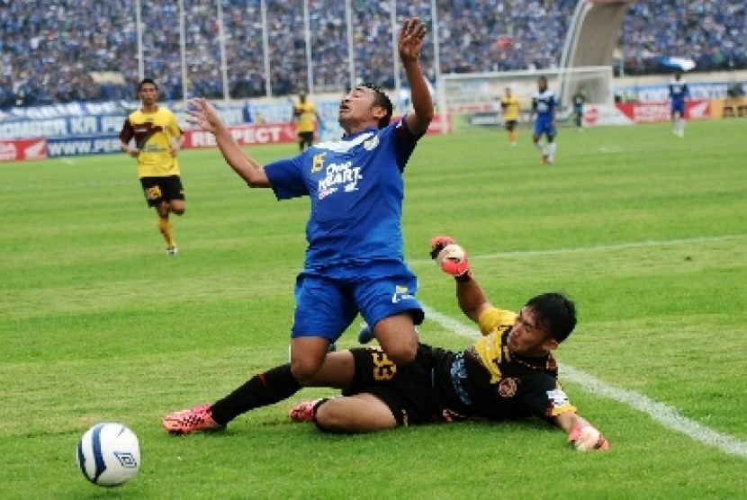 Pesepakbola Persib Bandung, Firman Utina (15) dijegal penjaga gawang Sriwijaya FC Rivky (33).