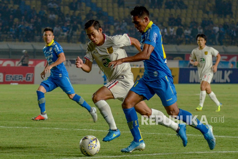 Pemain Persib Bandung Frets Butuan (kanan) berebut bola dengan pemain Persela Lamongan Ahmad Birrul dalam laga Liga 1 di Stadion Si Jalak Harupat, Selasa (3/12). Pelatih Persib Robert Alberts menilai timnya bermain buruk karena takluk 0-2 dari Persela.