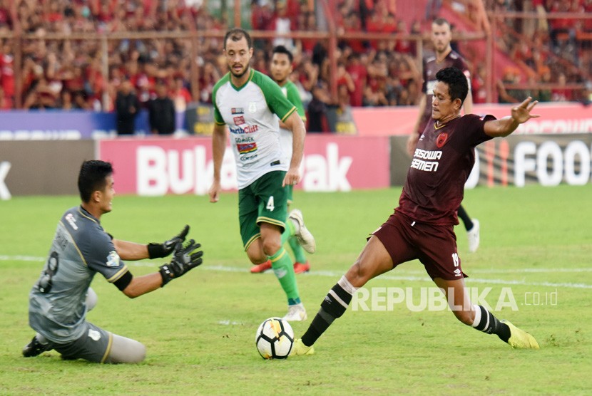 Pesepakbola PSM Makassar Rizki Pellu (kanan) berebut bola dengan penjaga gawang PSMS Medan Dhika Bayangkara (kiri) saat bertanding pada Lanjutan Liga 1 2018 di Stadion Andi Mattalatta Makassar, Sulawesi Selatan, Ahad (09/12/2018). 