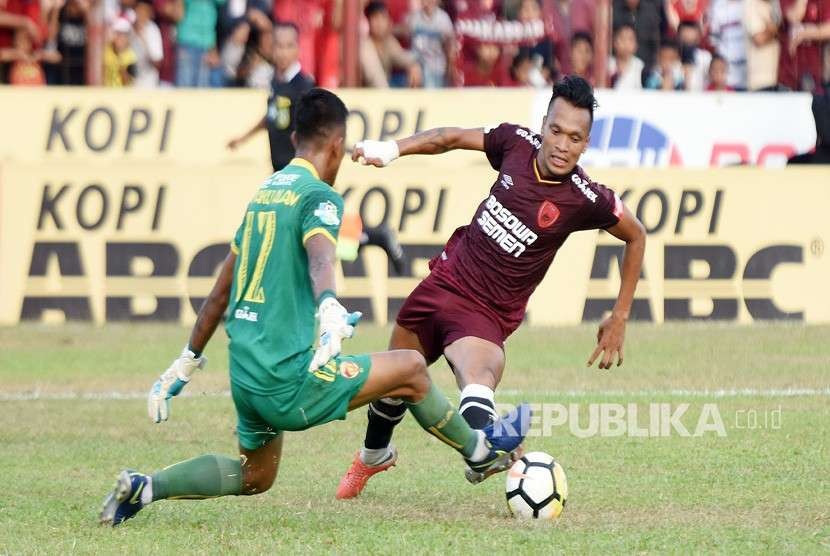 Pesepakbola PSM Makassar Ferdinand Sinaga (kanan) berusaha melewati penjaga gawang Sriwijaya FC T. Paku Alam (kiri), pada Lanjutan Liga 1 2018 di Stadion Mattoanging Gelora Andi Mattalatta Makassar, Sulawesi Selatan, Ahad (23/9). 