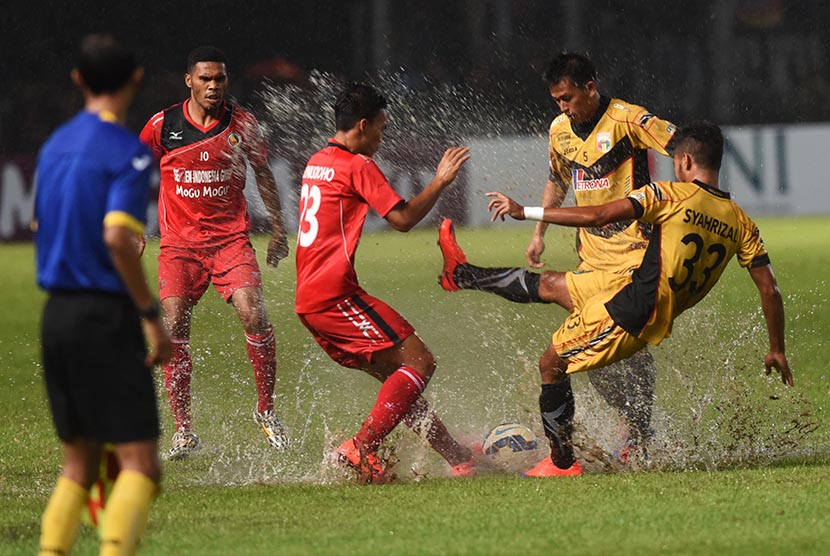 Pesepakbola Semen Padang Adi Nugroho (tengah) berebut bola dengan pesepakbola Mitra Kukar Syahrizal (kanan) dan Hendra Ridwan (kedua kanan) saat laga Final Piala Jenderal Sudirman di Stadion Utama Gelora Bung Karno, Jakarta, Ahad (24/1). 