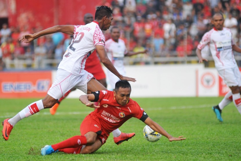 Pesepakbola Semen Padang FC Dedi Hartono (kanan) terjatuh saat berebut bola dengan pemain Persipura Valentino Telaubun (kiri) pada pertandingan lanjutan Liga 1 2019, di Stadion GOR H Agus Salim, Padang, Sumatera Barat, Kamis (24/10/2019). 