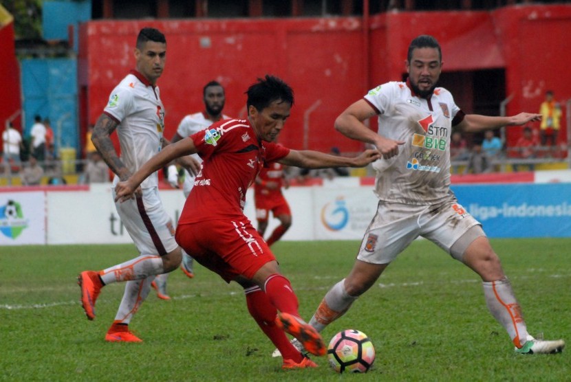 Pesepakbola Semen Padang FC, Rudi (kiri) melepaskan tendangan dibayangi pemain Pusamania Borneo FC, Yamashita Kunihiro (kanan), pada pertandingan lanjutan Liga 1, di Stadion GOR H Agus Salim Padang, Sumatera Barat, Kamis (31/8). 